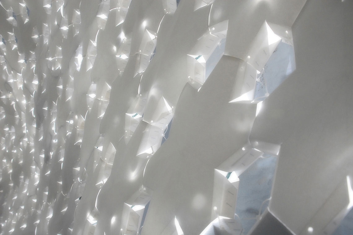 Photo showing a detailed view of lit up Daphne installation connected paper panels.