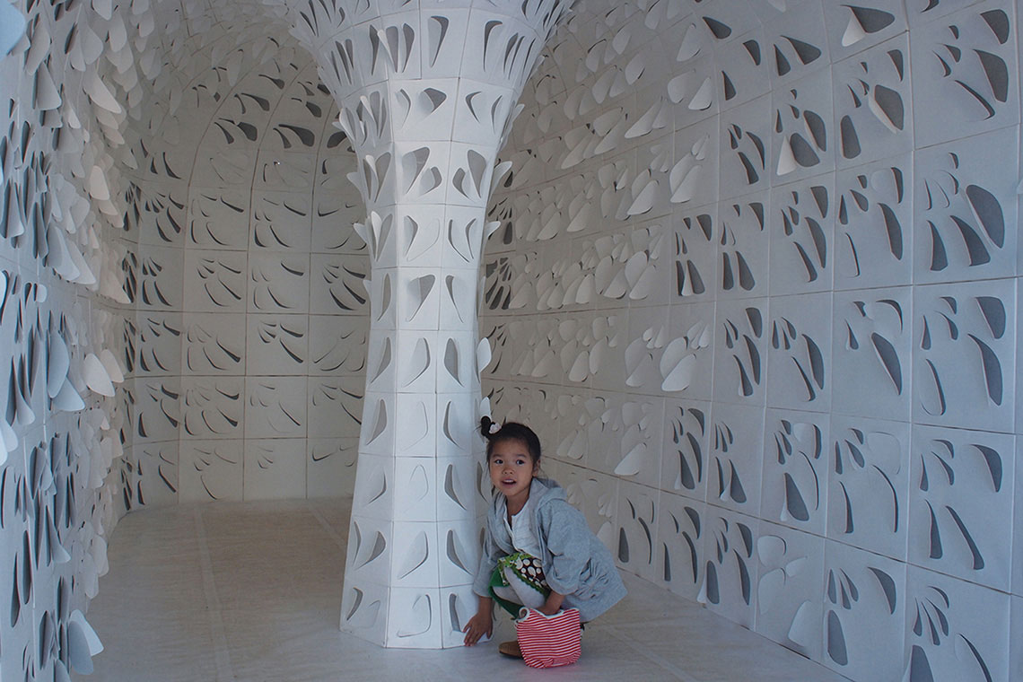 Photo of Hope Tree Installation made of self-supporting paper panels interior space during day time with little girl.