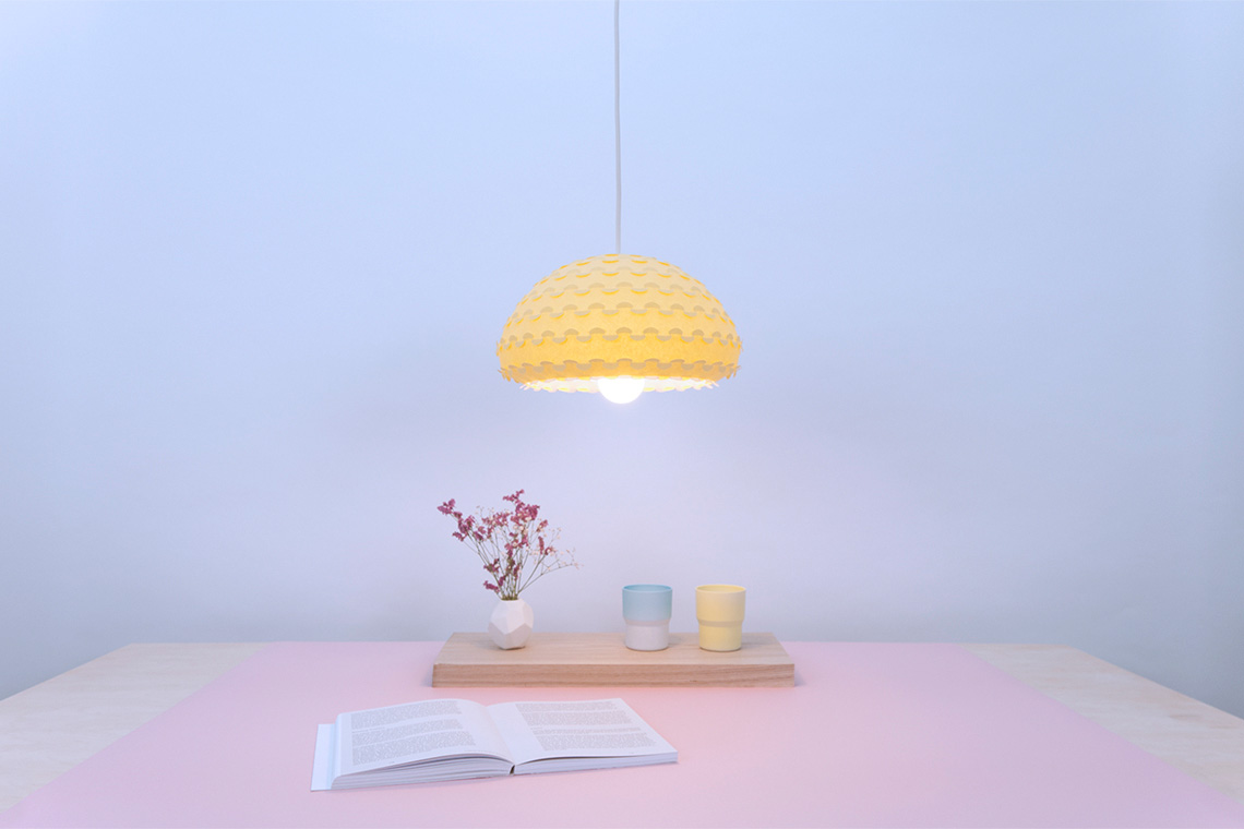 Kasa ceiling light in bright yellow color over a dining table interior view