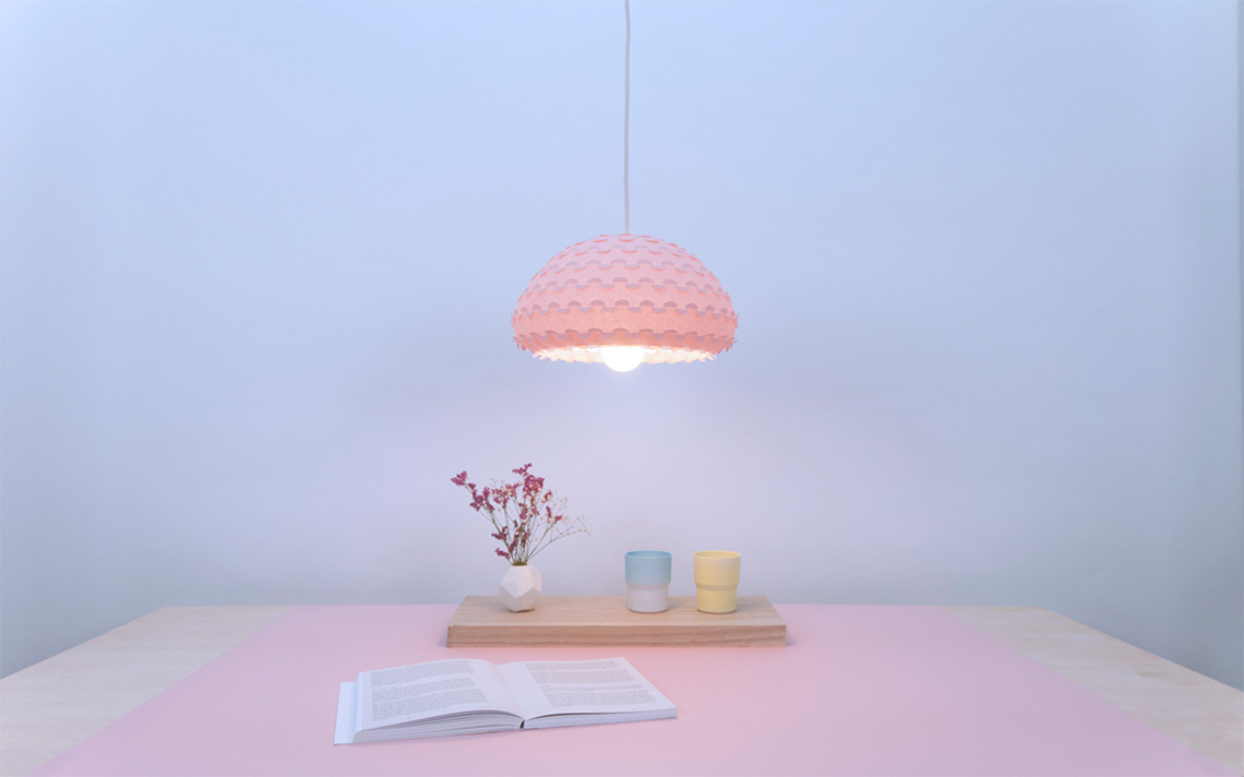 Kasa small hanging lamp in pastel pink color over a dining table interior view