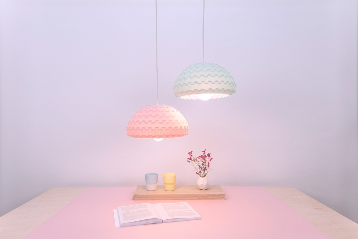 Kasa two pastel colored pendant lamps in green and pink colors over a dining room table