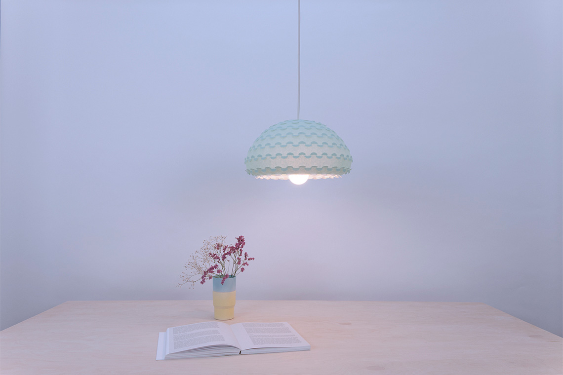 Kasa pendant lamp in mint green color over a dining table interior view